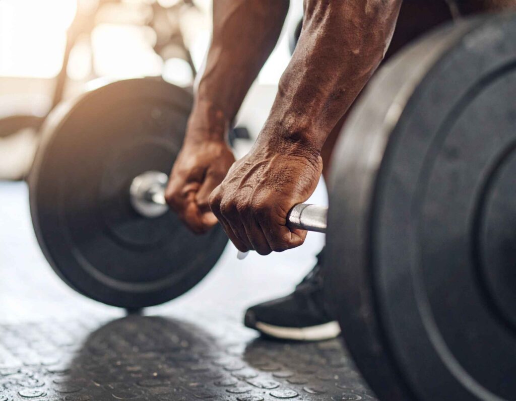 A lifter's hands firmly gripping a barbell, symbolizing the preparation for a lift calculated with the Lombardi formula 1RM